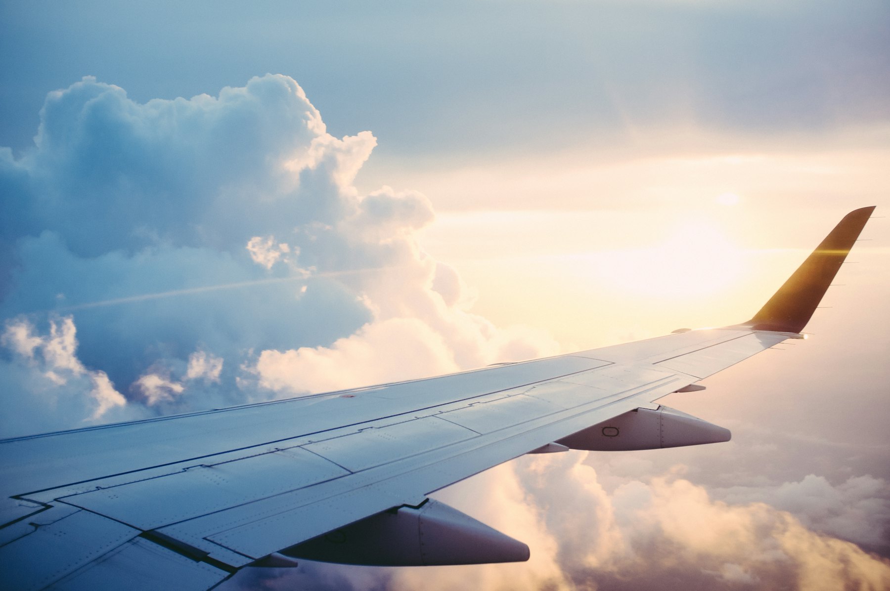 Aircraft wing above the clouds at sunrise